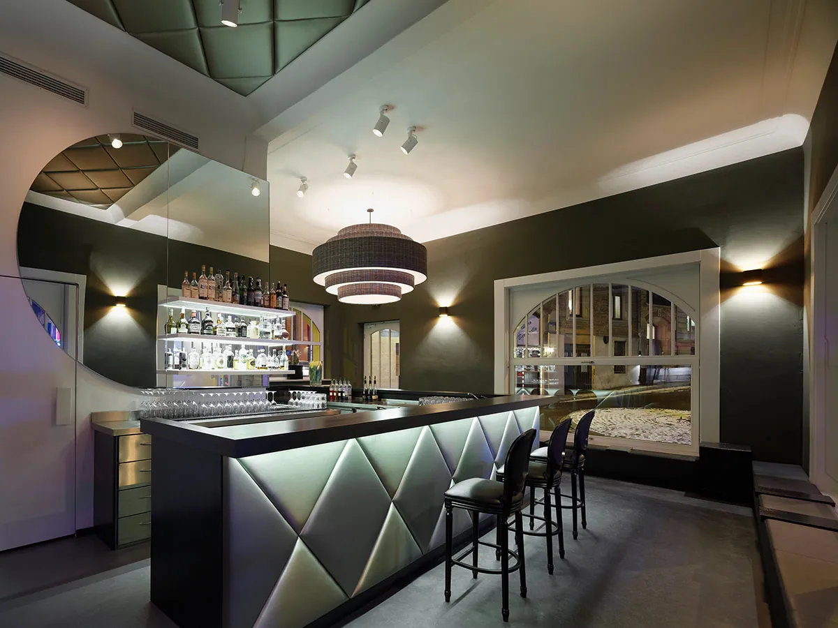 Innenraum der FOU FOU Cocktail- und Champagnerbar mit Theke, Barhockern und Hängelampe