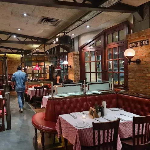 Speisesaal des Restaurants Pier 51 mit roten Lederbänken und Backsteinwand