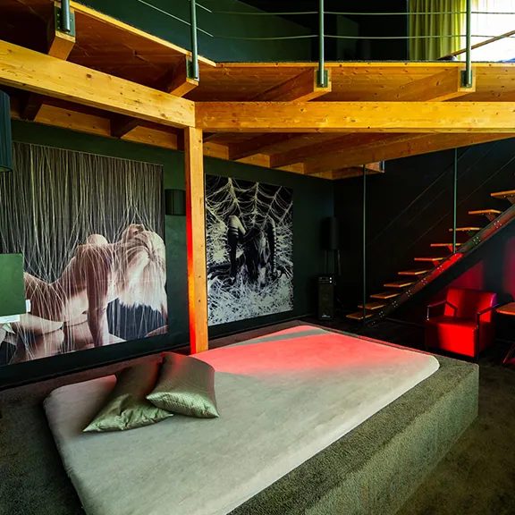 VIP-Raum im Sakura FKK Club mit Holzgalerie, Treppe, großem Bett und Wandbildern