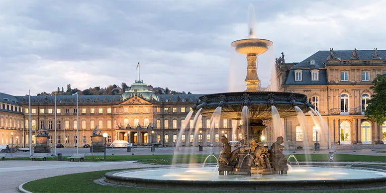 Springbrunnen vor einem Barockschloss in Stuttgart in der Abenddämmerung