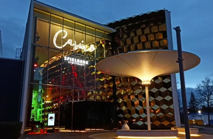 Außenansicht der Spielbank Stuttgart mit leuchtendem Casino-Schriftzug in der Abenddämmerung