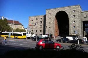Torbogen des Stuttgarter Hauptbahnhofs, in dem das InterCityHotel liegt, mit Bus und Autos davor