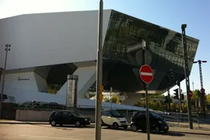 Weißer, kantiger Bau des Porsche-Museums in Stuttgart-Zuffenhausen mit parkenden Autos