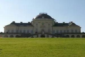 Schloss Solitude in Stuttgart mit Kuppel hinter einer weiten grünen Wiese